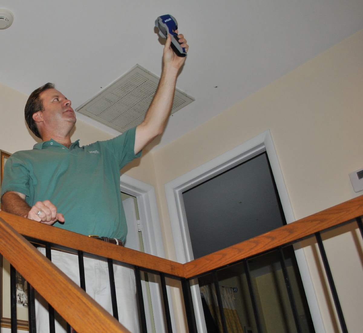 A homeowner reviewing rebate paperwork beside a new high-efficiency furnace